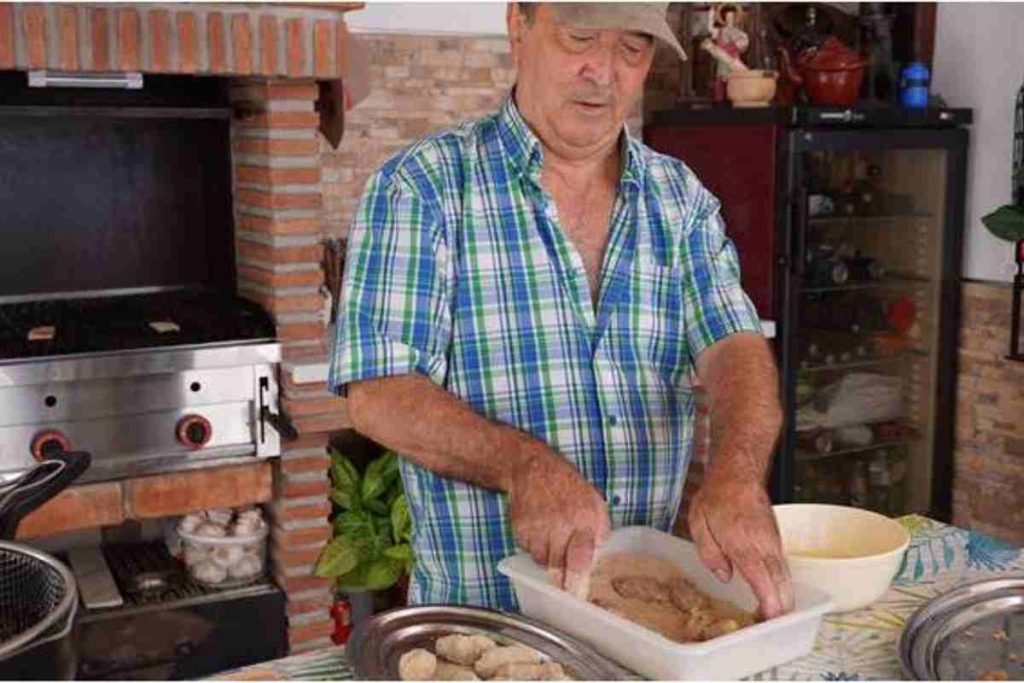 Man with a cap cooking something in the kitchen