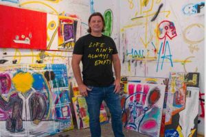 Pigsy standing in front of his artwork