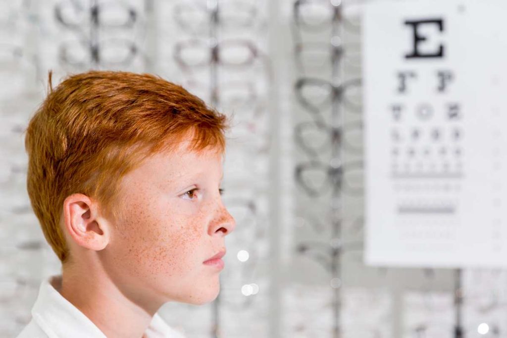 side-young-adorable-boy-with-freckle-his-face-standing-optics-shop